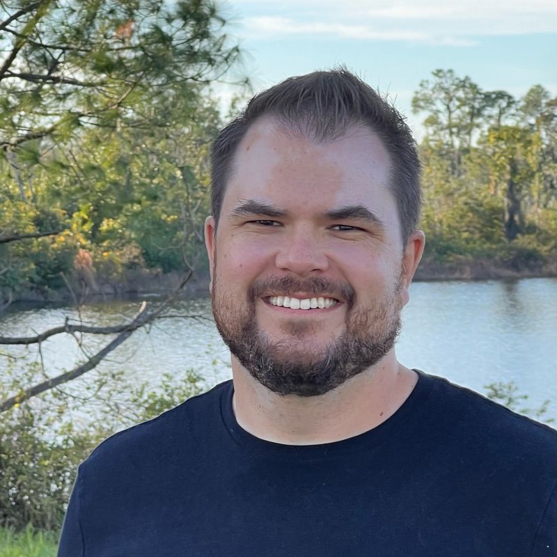 Marty Coressel, CPA, smiling outdoors by a lake